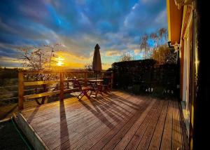 a wooden deck with a table and an umbrella at Countryside in the Town. in Harlescott