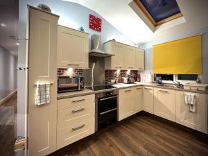 a kitchen with white cabinets and a stove top oven at Countryside in the Town. in Harlescott