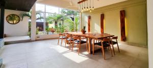 uma sala de jantar com uma mesa de madeira e cadeiras em Villa Pacha em Kampot