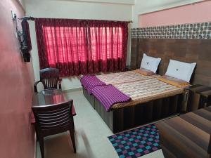 um pequeno quarto com 2 camas e uma janela em Sri vishnu krupa lodging em Belūr