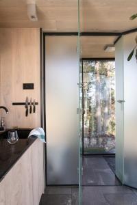a pivot door in a kitchen with a view of a woman at The WonderInn Mirrored Glass Cabin - Wonderinn Delta in Hektner
