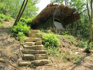 un camino que conduce a una cabaña de paja en Adrenaline Check Kaki Event Place, en Portorož