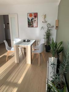 una sala da pranzo con tavolo e sedie bianchi di Appartement le 48 a Narbonne