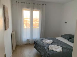 una camera da letto con un letto e due asciugamani di Appartement le 48 a Narbonne