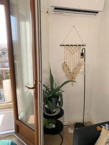 a living room with a plant and a lamp at Appartement le 48 in Narbonne