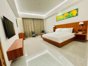 um quarto de hotel com uma cama e um telefone em The Mars Resorts em Meerut