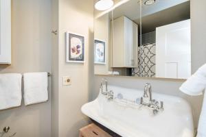a white bathroom with a sink and a mirror at Stylish Convenience! Short Walk to Lifts, Gondola, Main St, Fall Line 210 condo in Telluride +25 photos