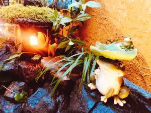 a frog with a mushroom on its head next to a plant at Nara Ryokan in Nara