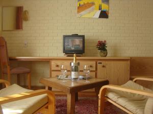 a living room with a table and a tv at Hôtel Restaurant N 4 in Martelange