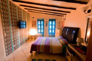 a bedroom with a bed and a tv on a wall at Villa Cococaribic Isla Margarita Venezuela in Paraguchi