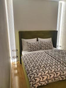 Schlafzimmer mit einem Bett mit einer schwarzen und weißen Bettdecke in der Unterkunft Apartment I Love Zagreb, free private parking in Zagreb