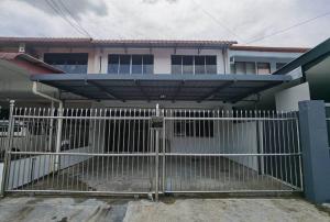 a white gate in front of a house at B&B Matu Road, Sibu in Sibu