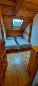 Podkrovie v zeleni - privat في شتربا: غرفة نوم صغيرة مع سرير في العلية