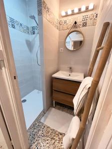 La salle de bains est pourvue d'une douche, d'un lavabo et d'un miroir. dans l'établissement L Abri-côtier Appartements, à Saintes-Maries-de-la-Mer