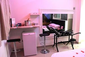 a room with a pink room with a desk and chair at Motel Vitória (Adult only) in Rialma