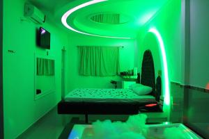 a green room with a bed and a tub at Motel Vitória (Adult only) in Rialma