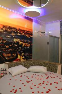 a bedroom with a bed with a painting on the wall at Motel Vitória (Adult only) in Rialma