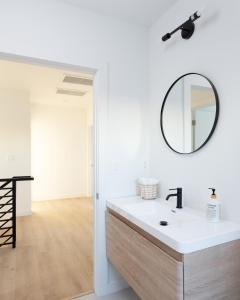 W łazience znajduje się biała umywalka i lustro. w obiekcie New Luxury Home with DTLA Views - Ideal for Groups w Los Angeles