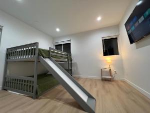Cette chambre pour enfants dispose de lits superposés et d'une télévision. dans l'établissement New Luxury Home with DTLA Views - Ideal for Groups, à Los Angeles