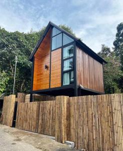 une petite maison au-dessus d'une clôture en bois dans l'établissement p.p. hill & house, à Ban Tha Phae