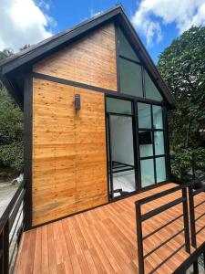a tiny house on a wooden deck with windows at p.p. hill & house in Ban Tha Phae