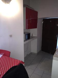 a small kitchen with a black door and a microwave at Studio Haute Ville in Corte