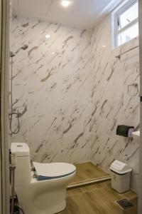 een badkamer met een toilet en een marmeren muur bij Carcar Eco Farm Resorts in Carcar