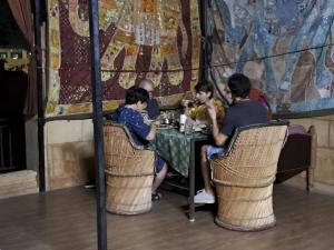 a group of people sitting at a table in a restaurant at Bob Cafe & Guest House Jaisalmer in Jaisalmer