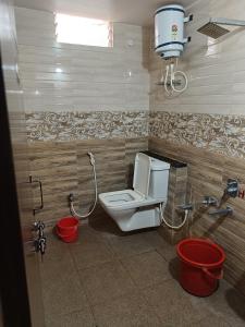 a bathroom with a toilet and a shower in it at Sri vishnu krupa lodging in Belūr