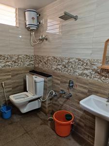 a bathroom with a toilet and a sink at Sri vishnu krupa lodging in Belūr