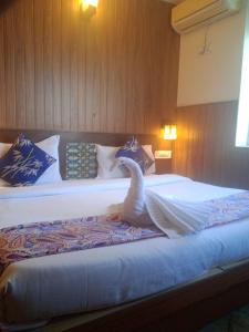 a bedroom with a bed with a swan on it at Hotel The Rotisserie By WB Inn in Behror