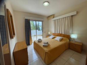 a bedroom with a bed and a window at Pissouri Beach Apartments in Pissouri