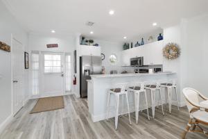 a kitchen with white cabinets and white stools at Waterfront luxury Villa 43 with spectacular sunset views and boat slip townhouse in Marathon