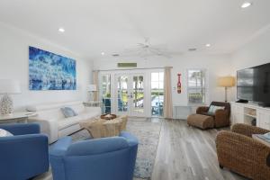 a living room with a white couch and blue chairs at Waterfront luxury Villa 43 with spectacular sunset views and boat slip townhouse in Marathon
