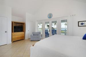 une chambre blanche avec un lit et une télévision dans l'établissement Waterfront luxury Villa 54 with sunset views and boat slip townhouse, à Marathon 38 autres photos