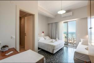 sypialnia z 2 łóżkami i widokiem na ocean w obiekcie Frini Hotel w Chanii
