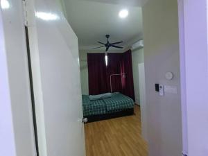 a room with a ceiling fan and a bed at HS Homestay in Sandakan