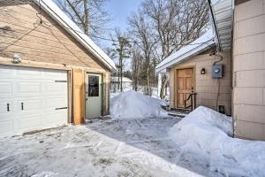 a garage with snow next to a house at Family Home - Walk to Town and Balsam Lake! in Balsam Lake