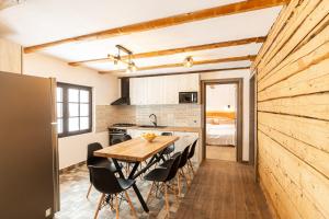 a kitchen and dining room with a wooden table and chairs at Casa Sena in Moieciu de Sus