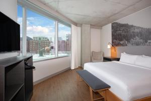 a hotel room with a bed and a large window at Hotel Indigo Denver Downtown - Union Station by IHG in Denver +67 photos