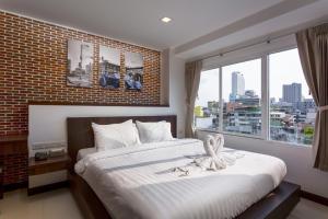 um quarto com uma cama grande e uma janela grande em U Hatyai Hotel em Hat Yai