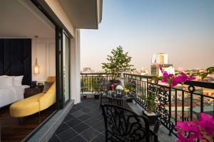 ein Hotelzimmer mit einem Balkon mit einem Bett und Aussicht in der Unterkunft Soleil Boutique Hotel Hanoi in Hanoi