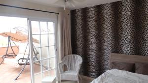 - une chambre avec un lit, une chaise et une fenêtre dans l'établissement Arenita Apartment, à Palm-mar