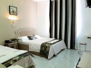 a hotel room with two beds and a window at Euro Vacances Guest House in Roches Brunes +7 photos
