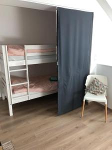 Zimmer mit 2 Etagenbetten und einem Stuhl in der Unterkunft La maison d’à côté in Troyes