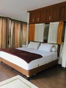 um quarto com uma cama grande e armários de madeira em Villa Gathering Yuni Syahla em Citaringgul 1