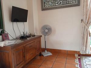um quarto com uma secretária, uma ventoinha e uma televisão em Villa Gathering Yuni Syahla em Citaringgul 1