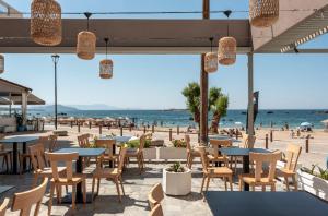 a group of tables and chairs on a beach at Frini Hotel in Chania