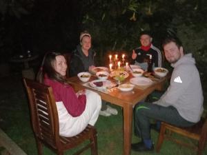 eine Gruppe von Menschen, die an einem Tisch mit Essen sitzen in der Unterkunft Lily Bank Cottage in Nuwara Eliya
