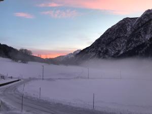 una strada ricoperta di neve con montagne sullo sfondo di Alpin 1100 a Steeg